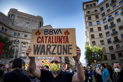 Un protestante sostiene una pancarta en Barcelona durante las movilizaciones contra el ERE de BBVA. / Paco Freire