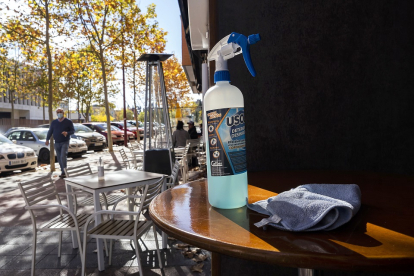 Un bote de gel hidroalcohólico sobre una mesa de la terraza un bar. PHOTOGENIC / PABLO REQUEJO