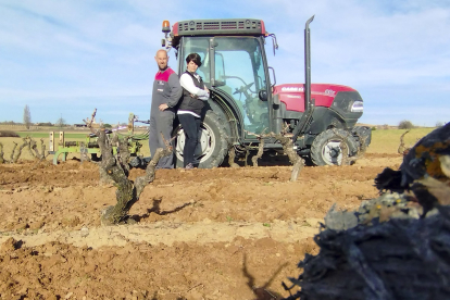 Tomás Bueno y Marta Llorente posan  junto a su tractor en una de sus viñas. ECB