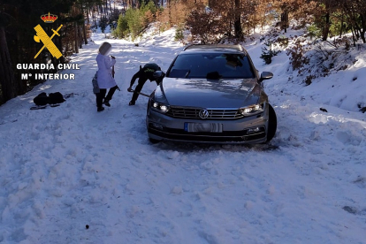 Agentes de la Guardia Civil auxilian a la familia atrapada en la nieve. | E.M.