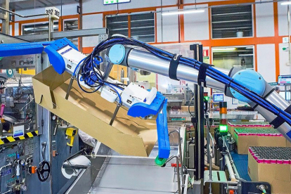 Un robot maneja una caja en la fábrica de productos capilares del grupo L’Oréal de Burgos.  (EL MUNDO)