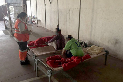 Miembros de Cruz Roja colaboran con los vecinos desalojados de sus viviendas por el incendio en una fábrica de pinturas situada en el polígono industrial de San Pedro del Arroho (Ávila).- ICAL