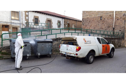 Un operario de la Junta desinfectando contenedores de basura en Quintanar. ECB