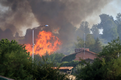 Un virulento incendio arrasa una zona arbolada con viviendas y líneas eléctricas entre San Andrés y Ferral del Bernesga (León).- ICAL