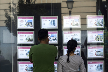 Una pareja de jóvenes ven anuncios de una inmobiliaria.-  JAVI MARTÍNEZ