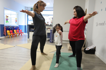 La profesora de yoga Mónica Santamaría supervisa un ejercicio con Laura y su hija Lara