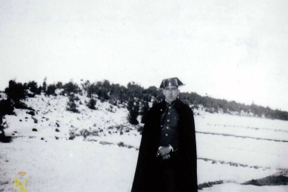 El cabo Isidoro Heras Molinero posa de uniforme con las prendas características de capa y sombrero negro en paisaje invernal. 1934