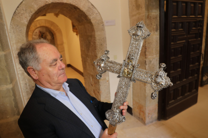 El delegado de Patrimonio Cultural de la Diócesis de Palencia sujeta la cruz procesional