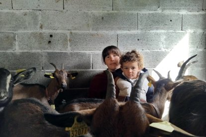 María, que cambia de vida y se muda al campo a sus 30 años, posa con su hijo y algunas de sus cabras