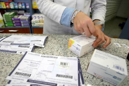 Una farmacéutica recorta el identificador del medicamento.-Ical