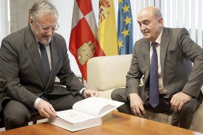 Carlos Pollán recibe el informe de manos de Tomás Quintana