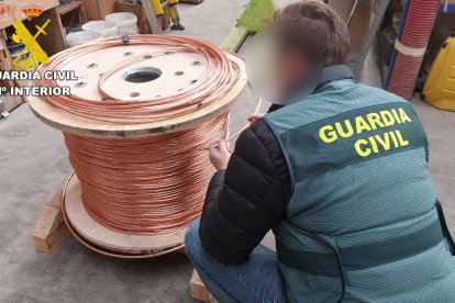 Agente de la Guardia Civil con un rollo de cobre intervenido.