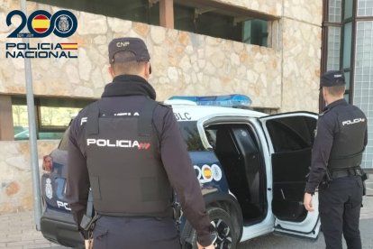 Dos agentes de la Policía Nacional, de espaldas.