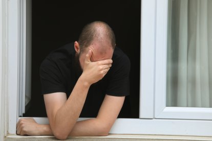 Un joven en la ventana de su domicilio.