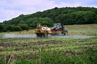 Un agricultor rocía un fertilizante en un campo de cultivo.