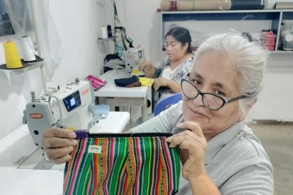 Una mujer peruana muestra uno de los bolsos elaborados en un taller de Paita