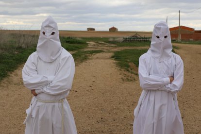 Unos penitentes en la Procesión de La Carrera en Villarrín de Campos (Zamora), al fondo unos palomares.