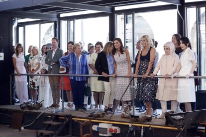 La reina Letizia con los acompañantes de los mandatarios que asisten a la cumbre de la OTAN en su visita a la Fábrica de Vidrio en la Granja de San Idelfonso, Segovia.- ICAL