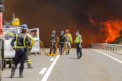 Efectivos de los bomberos de Segovia, de la Junta de Castilla y León y Protección Civil trabajan en la extinción del incendio en la Nacional-110.- ICAL