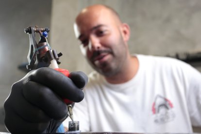 El tatuador leonés  Víctor Colado en All Street Barber & Tattoo Studio de la capital leonesa.- ICAL