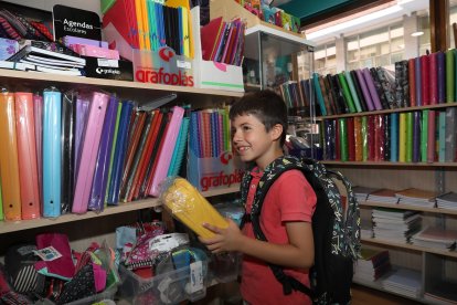 Un joven alumno se prueba una mochila para el nuevo curso escolar en una librería de la ciudad.- ICAL