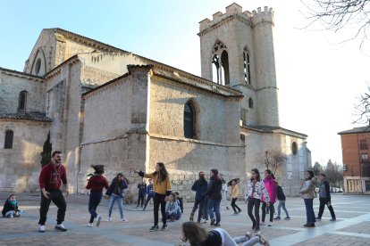 Algunos de los integrantes del Grupo Scout San Miguel de Palencia juegan a la vaca sentada en la plaza de San Miguel.-ICAL