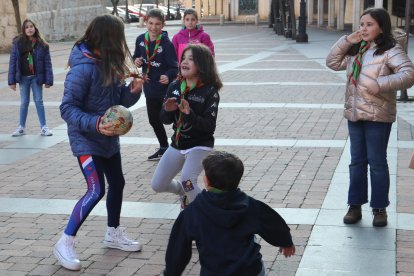 Algunos de los integrantes del Grupo Scout San Miguel de Palencia juegan a la vaca sentada en la plaza de San Miguel.-ICAL