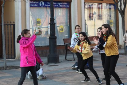 Algunos de los integrantes del Grupo Scout San Miguel de Palencia juegan a la vaca sentada en la plaza de San Miguel.-ICAL