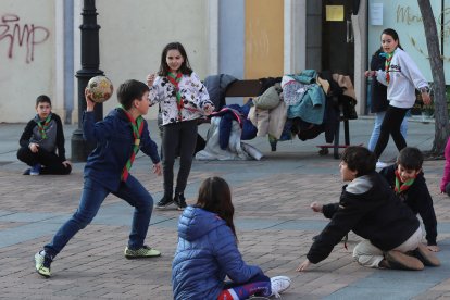 Algunos de los integrantes del Grupo Scout San Miguel de Palencia juegan a la vaca sentada en la plaza de San Miguel.-ICAL