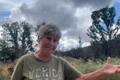 Nelly muestra el terreno calcinado cercano a la casa que el fuego quemó en el incendio de la Sierra de la Culebra el año pasado y que hoy se está reconstruyendo. A. CALVO