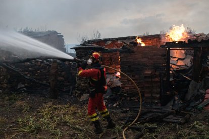 Un bombero trata de apagar el fuego del incendio de Puercas,