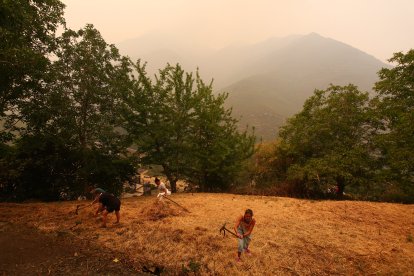Vecinos de Lusio (León), realizan desbroces alrededor del pueblo ante la posible llegada del incendio.