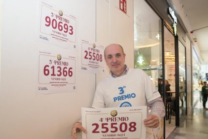 Luis Vázquez, de 'La Rana de Oro' de Río Shopping, en Valladolid, con los premios entregados de la Lotería de Navidad