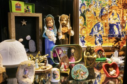 Fernando Gutiérrez y su padre muestran algunas de las piezas de su colección de 250 belenes, reunida a lo largo de los años.