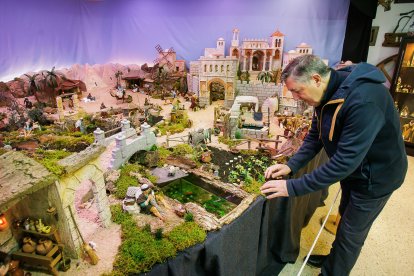 Fernando Gutiérrez y su padre muestran algunas de las piezas de su colección de 250 belenes, reunida a lo largo de los años.