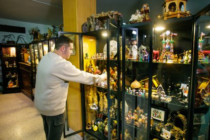 Fernando Gutiérrez y su padre muestran algunas de las piezas de su colección de 250 belenes, reunida a lo largo de los años.