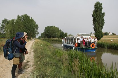El Canal de Castilla, la gran ruta del interior que impulsa el turismo activo en Palencia, en la imagen barco de recreo y peregrinos a Santiago en Frómista(Palencia)