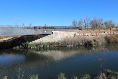 El Canal de Castilla, la gran ruta del interior que impulsa el turismo activo en Palencia, puente para bicis y peatones que cruza el canal por el antiguo trazado del Tren Burra