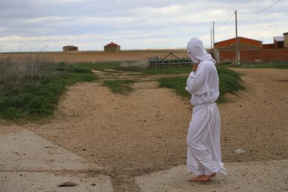 Unos penitentes en la Procesión de La Carrera en Villarrín de Campos (Zamora), al fondo unos palomares.