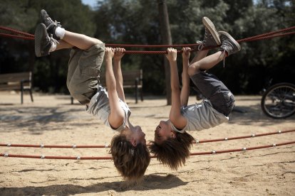 Dos gemelos juegan sincronizados en un parque, una imagen que refleja la conexión única entre hermanos idénticos