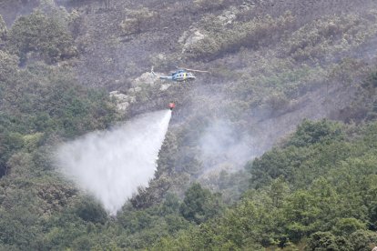 Labores de extinción de un incendio forestal originado esta madrugada en Valdepiélago (León).