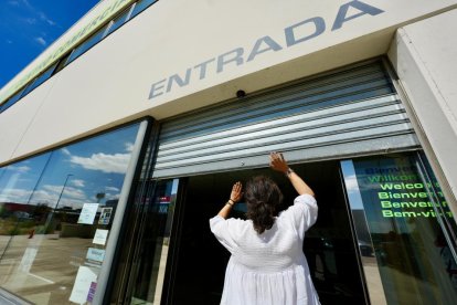 Trabajadora abriendo las persianas de su negoco