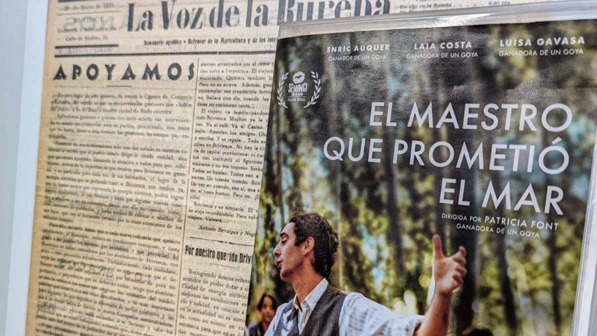 Un ordenador de la Biblioteca de Castilla y León muestra un ejemplar del periódico 'La Voz de la Bureba' ante el cartel de la película 'El maestro que prometió el mar', sobre la figura de Antonio Benaiges.