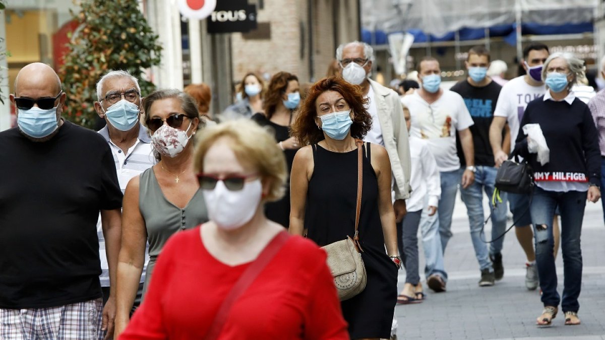 Gente con mascarillas camina por las calles de Valladolid. / J. M. LOSTAU.