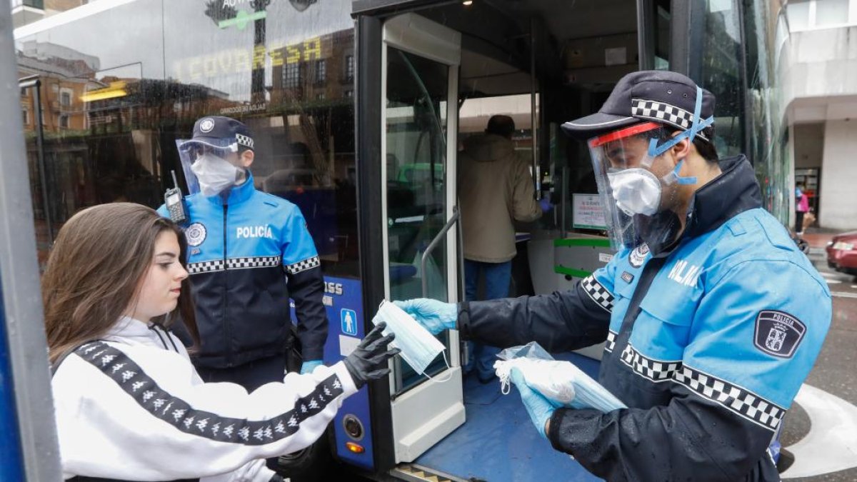 Policía reparte mascarillas a los usuarios del transporte urbano en la Plaza España de Valladolid. - JUAN MIGUEL LOSTAU