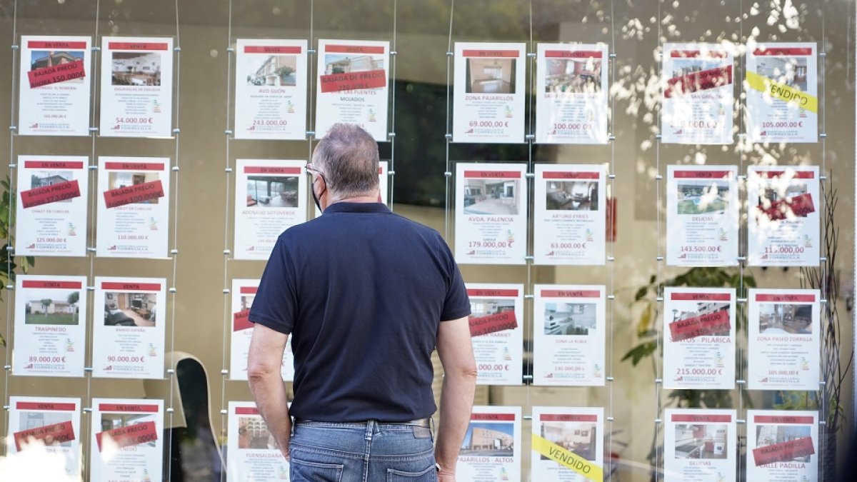 Un hombre observa pisos en venta y alquiler en una inmobiliaria. -ICAL