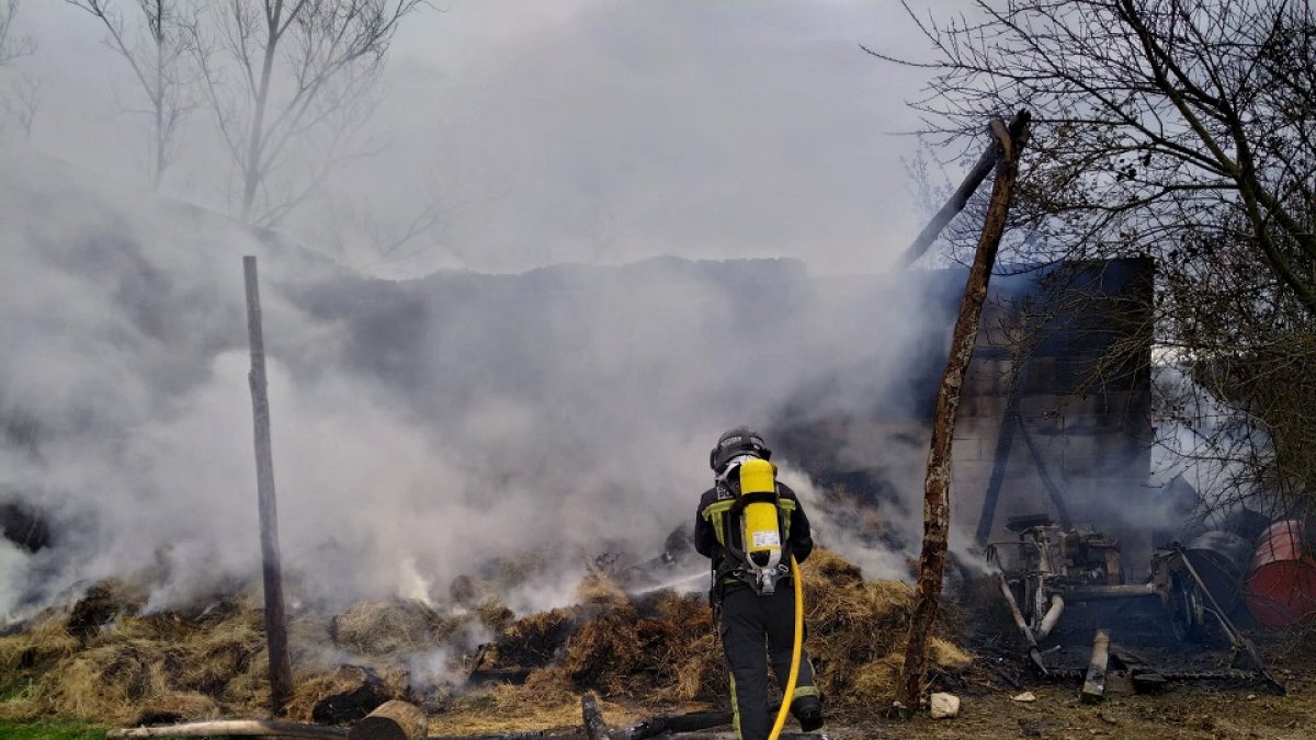 Bombero tratando de extinguir el incendio de una nave en Albares de la Ribera, León. -ICAL
