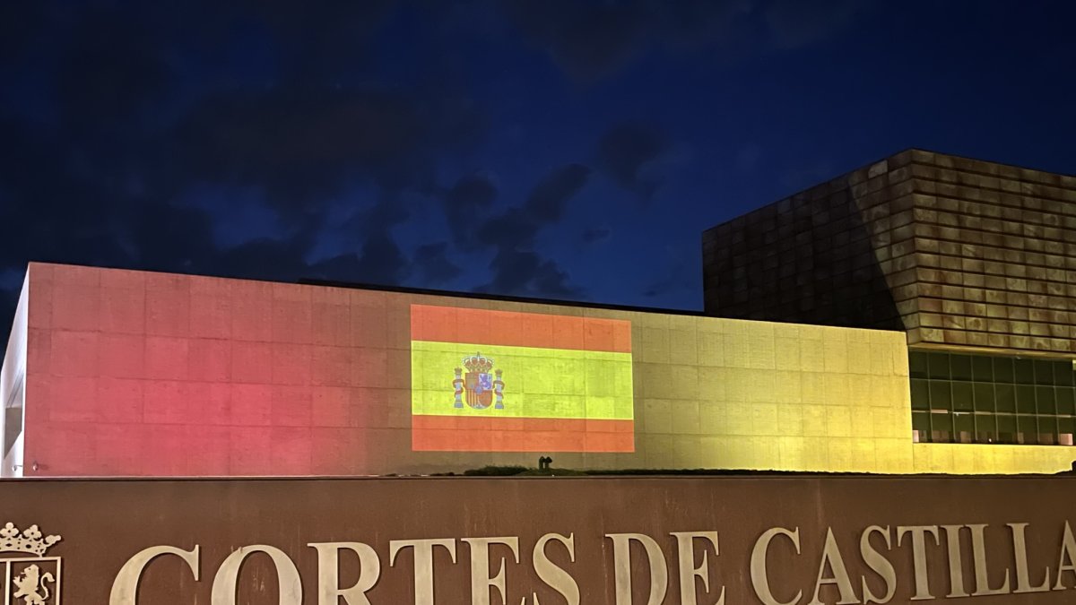 La fachada de las Cortes iluminada con la bandera de España.