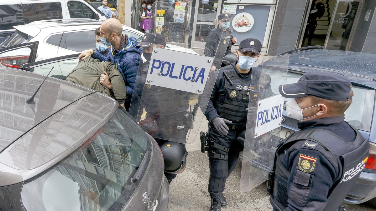 Los agentes introducen en el coche a uno de los detenidos en Burgos. -SANTI OTERO