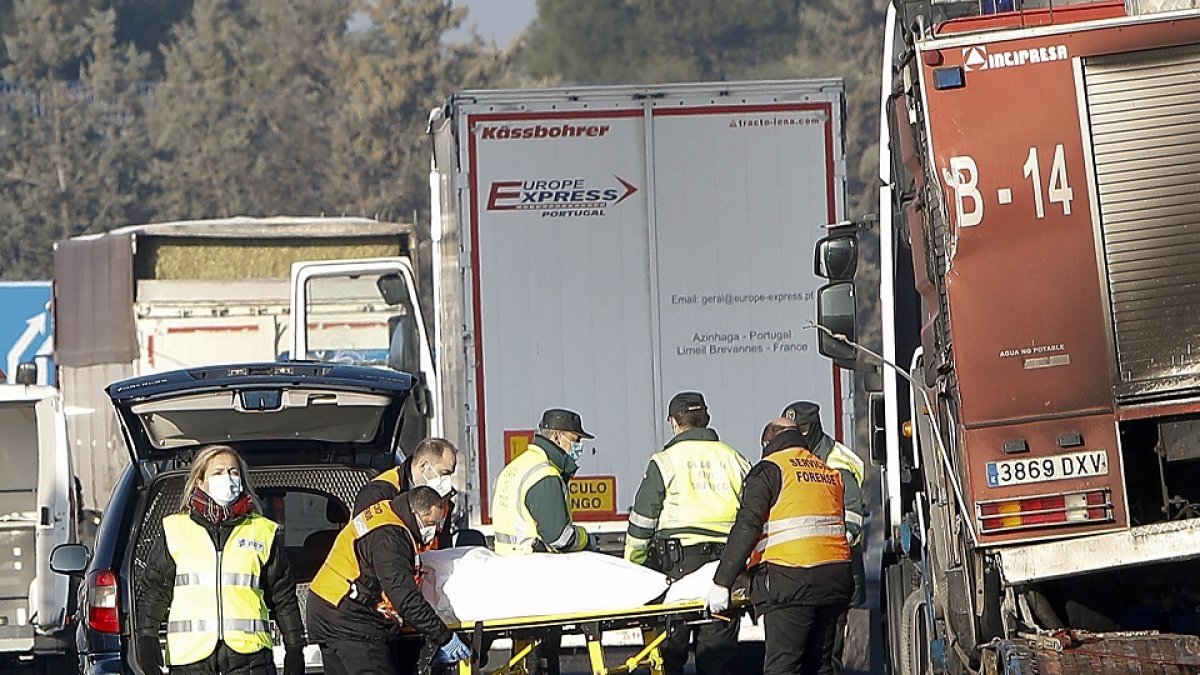 Agentes del Servicio Forense retiran el cadáver de una de las víctimas sobre la A-62, en el término de Tordesillas, ayer. J.M. LOSTAU